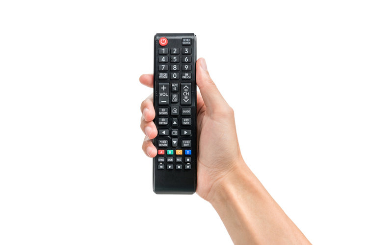 hand holding a black TV remote control