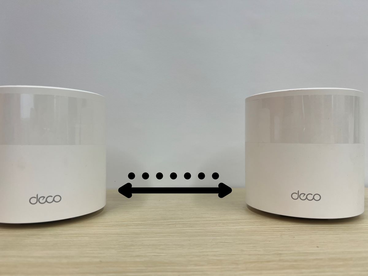 Distance between two nodes Deco Mesh Wi-Fi on a wooden table