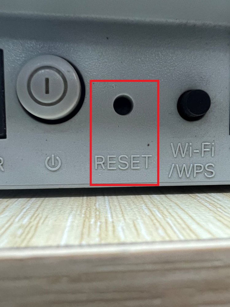 The reset button at the back of the TP-Link router