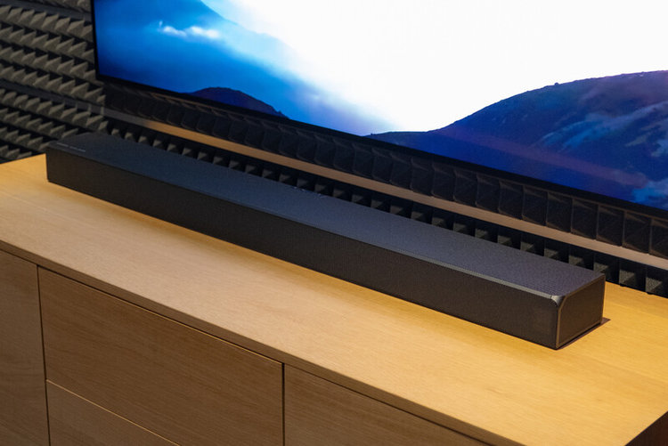 a soundbar on the wooden stand in front of the TV