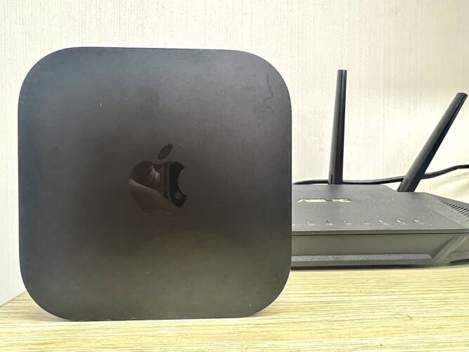 an apple tv next to an asus router