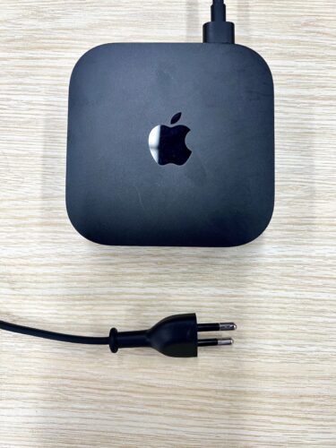 an apple tv with a part of a power cord on the table