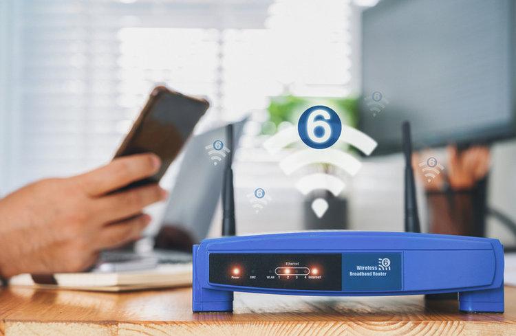 closeup view of router with wifi 6 and a man using smartphone in the background