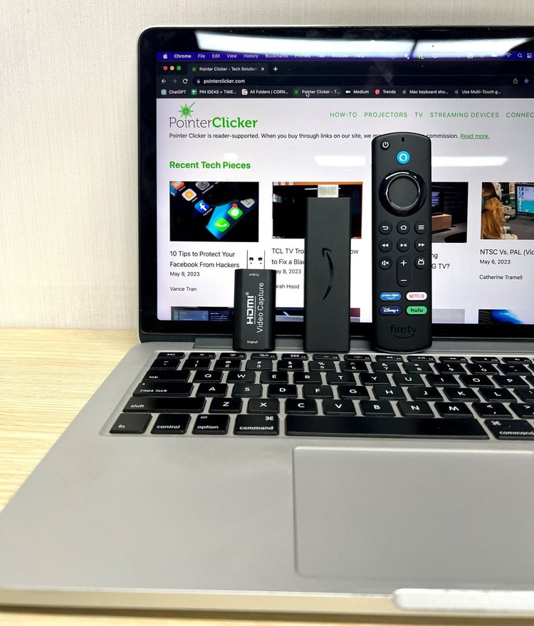 fire tv stick, remote, and a capture card are standing on a macbook