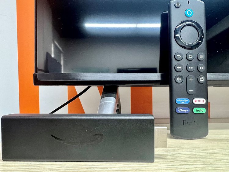 fire tv stick standing at a leg of a tcl tv