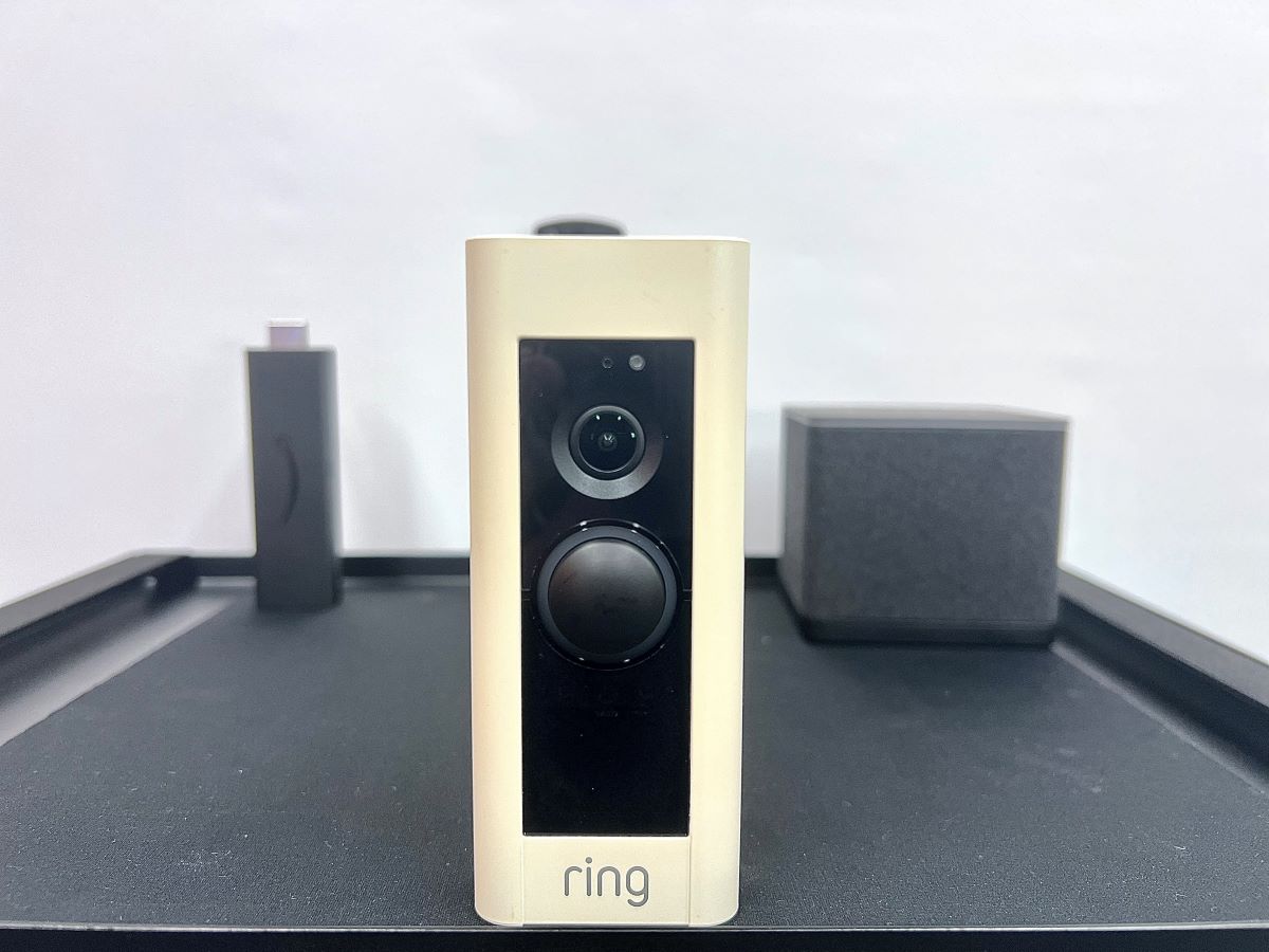 ring doorbell on a tripod stand with a fire tv stick & cube in the background