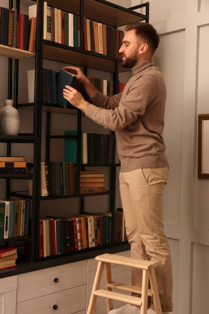 a man is organizing bookshelves