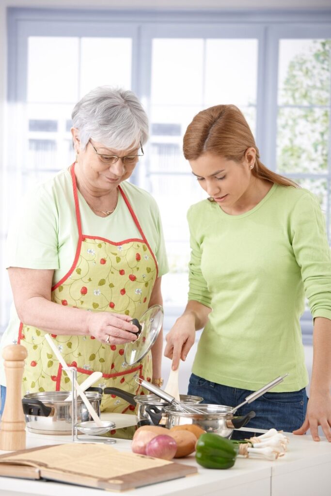 a woman and her mom are cooking in the kitchen