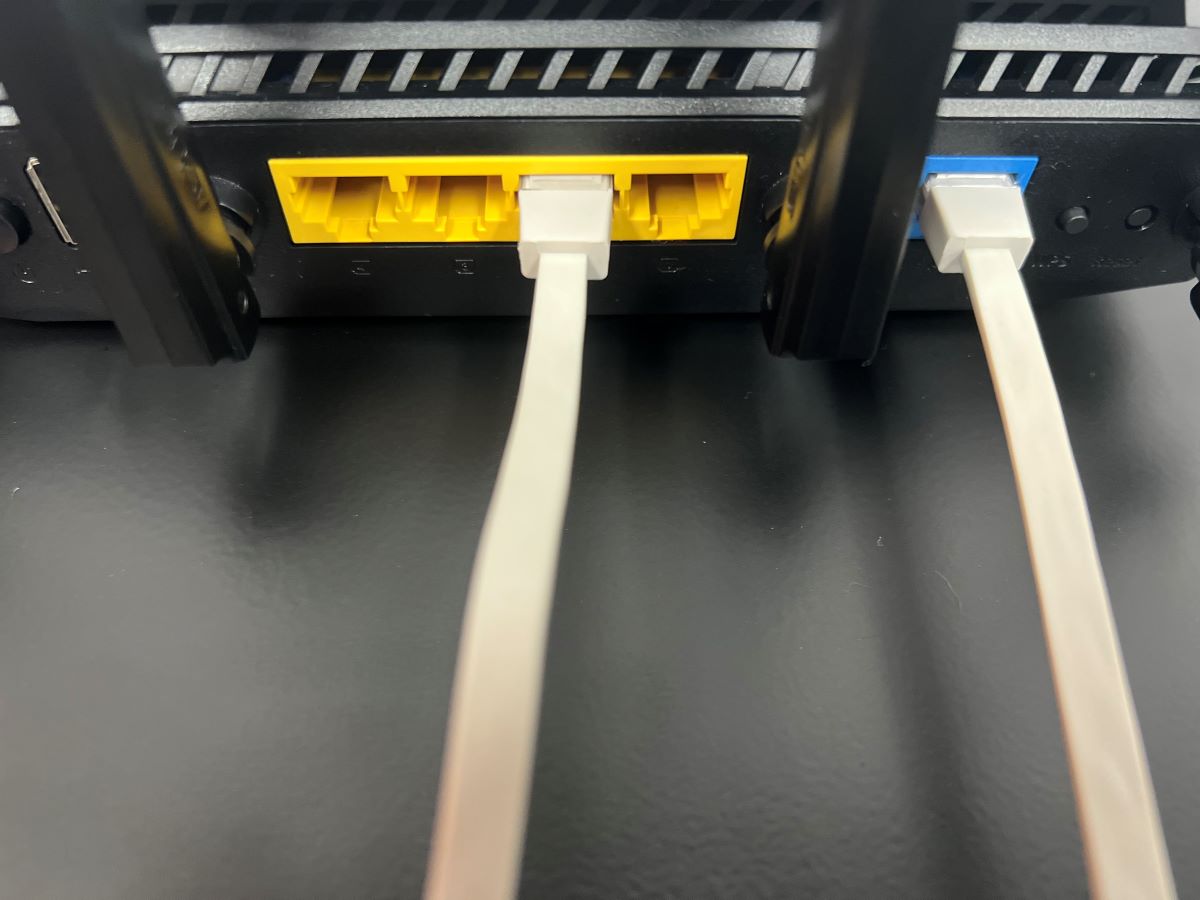 An Ethernet cable is connected to the Ethernet port on Asus router, another ethernet cable is connected to the LAN port