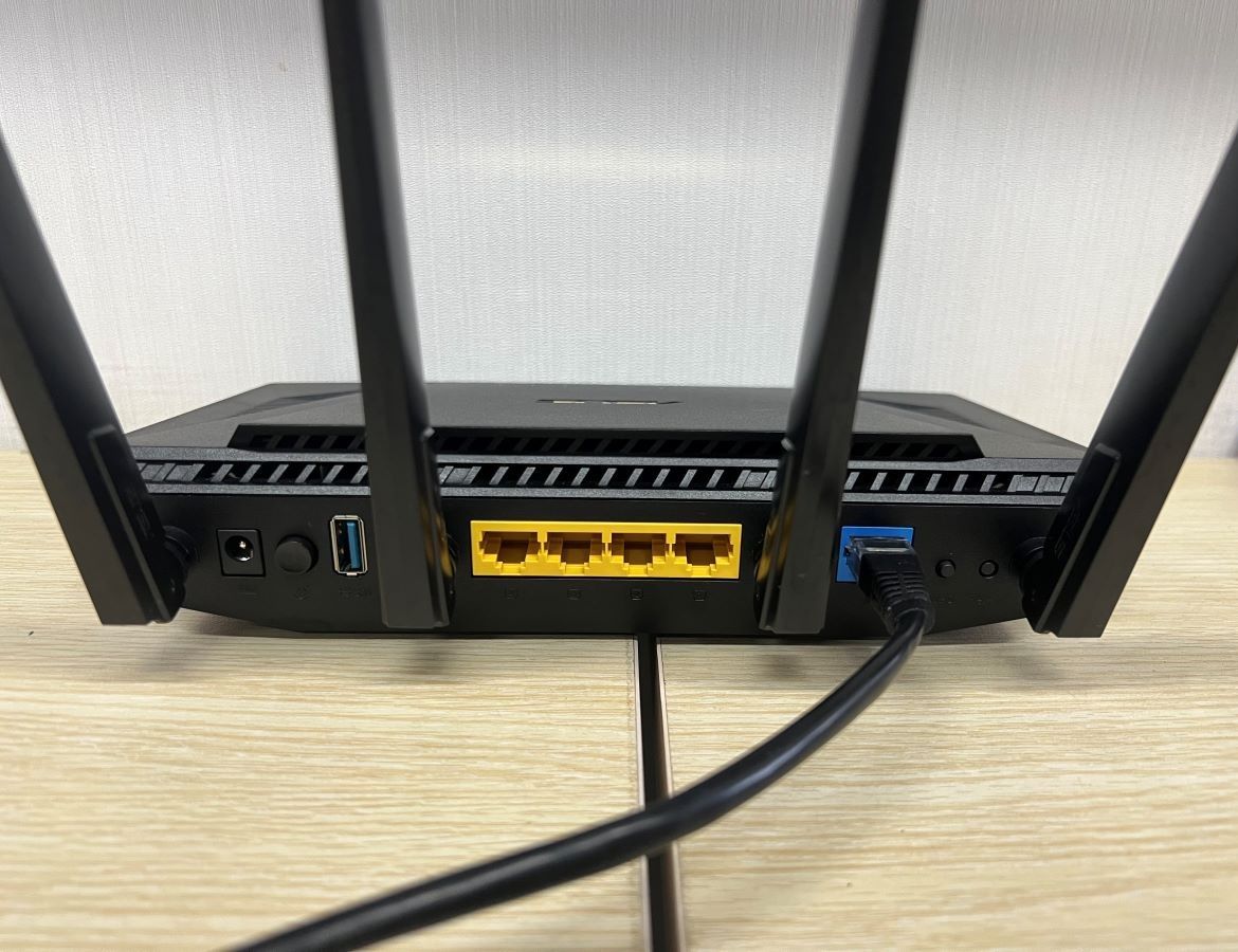 Ethernet cable is plugged into the Ethernet port of the Asus router