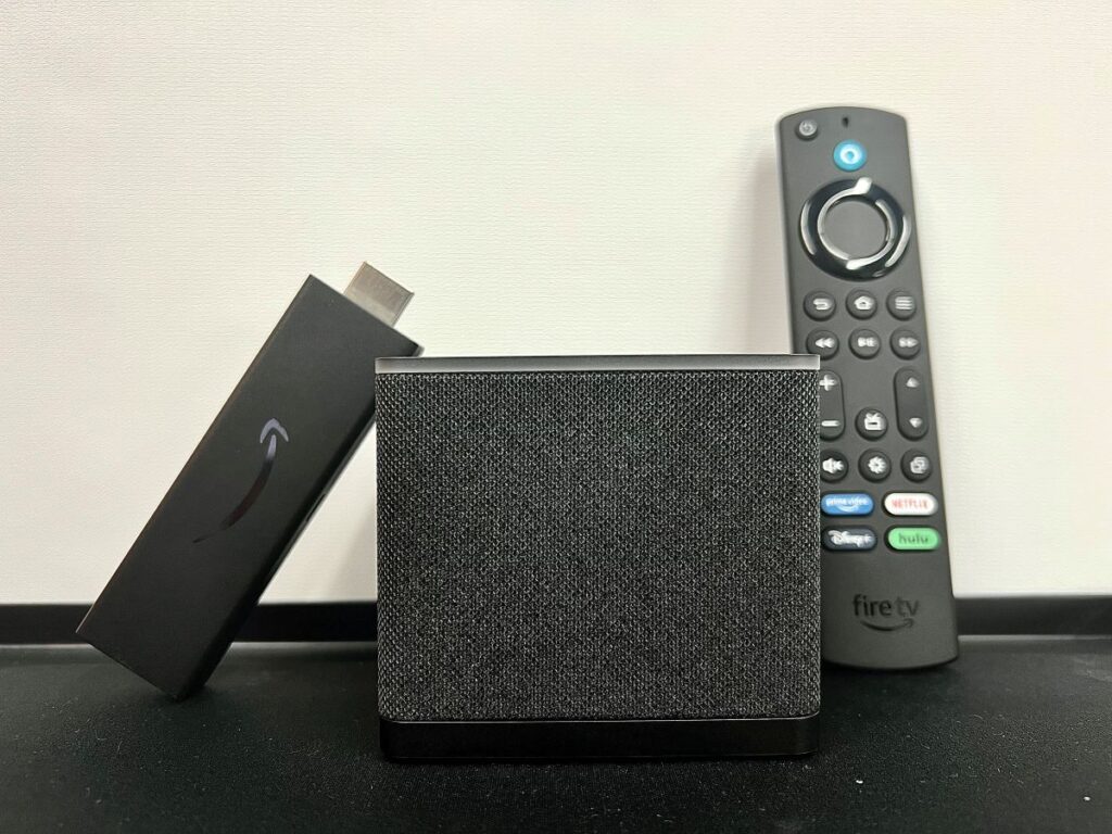 a fire tv stick next to a cube next to its remote