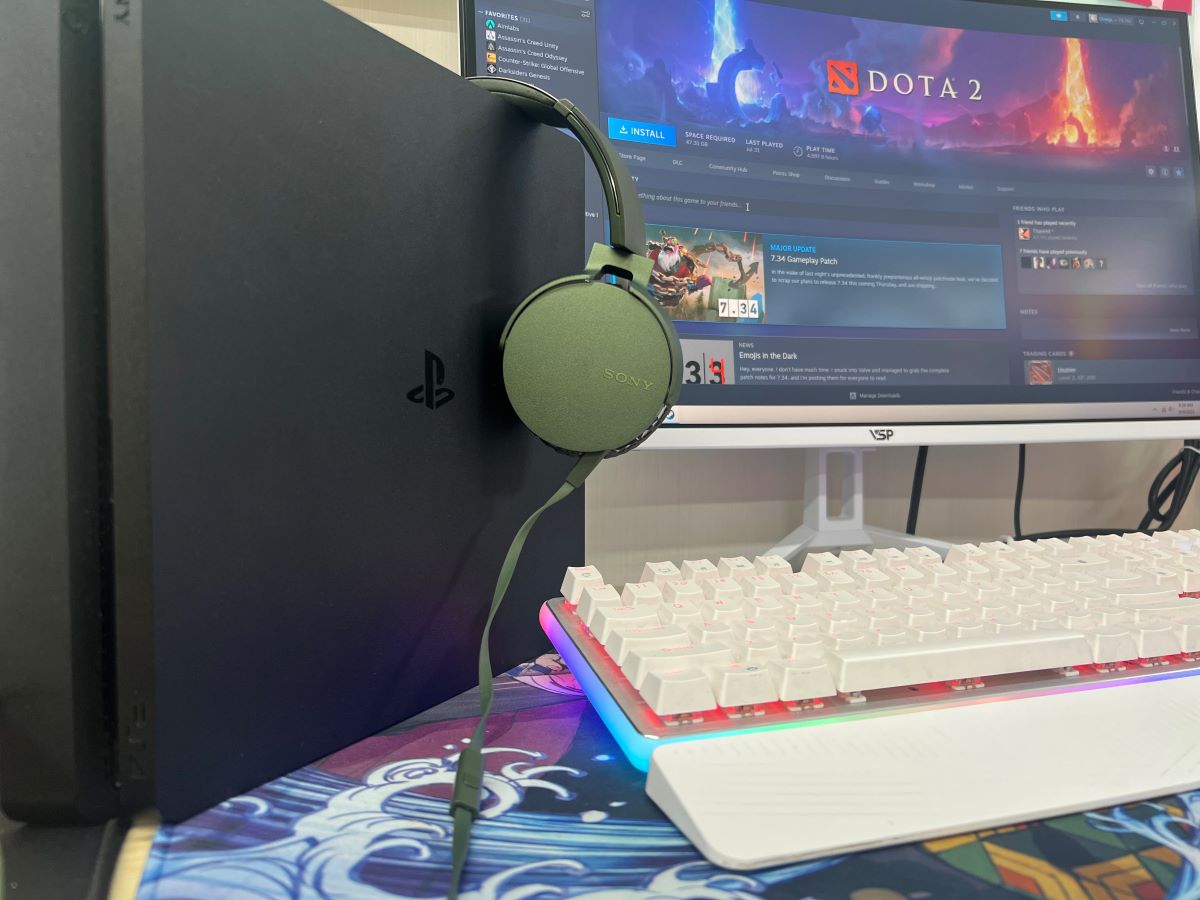 A green Sony headphones with a PS4 with a monitor showing Dota 2 from steam