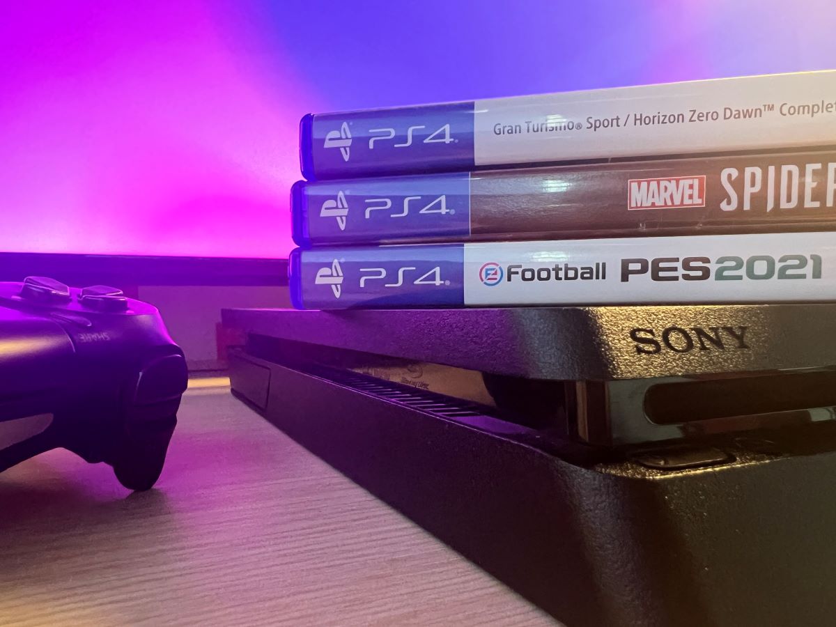 PS4 game disc with the console and the controller with the Neon purple background