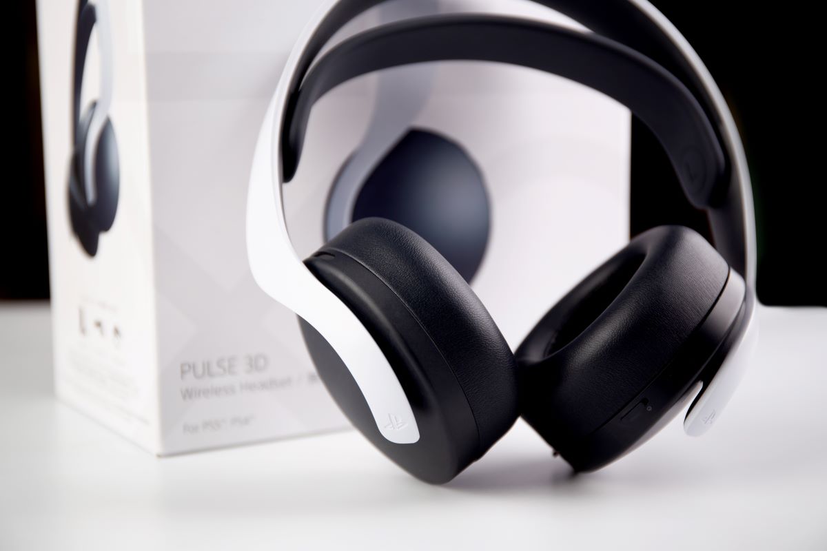 The PS5 headset Pulse 3D with the box at the back on a white table with black background