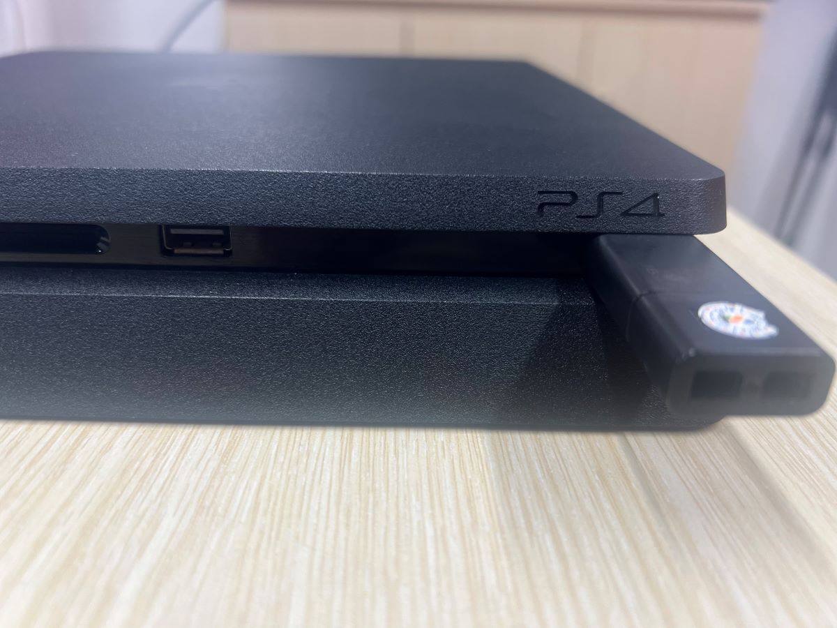 The USB flash drive is plugged into the PS4 console via a USB-A port