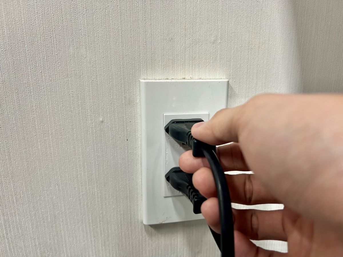 a hand unplugging a power cord