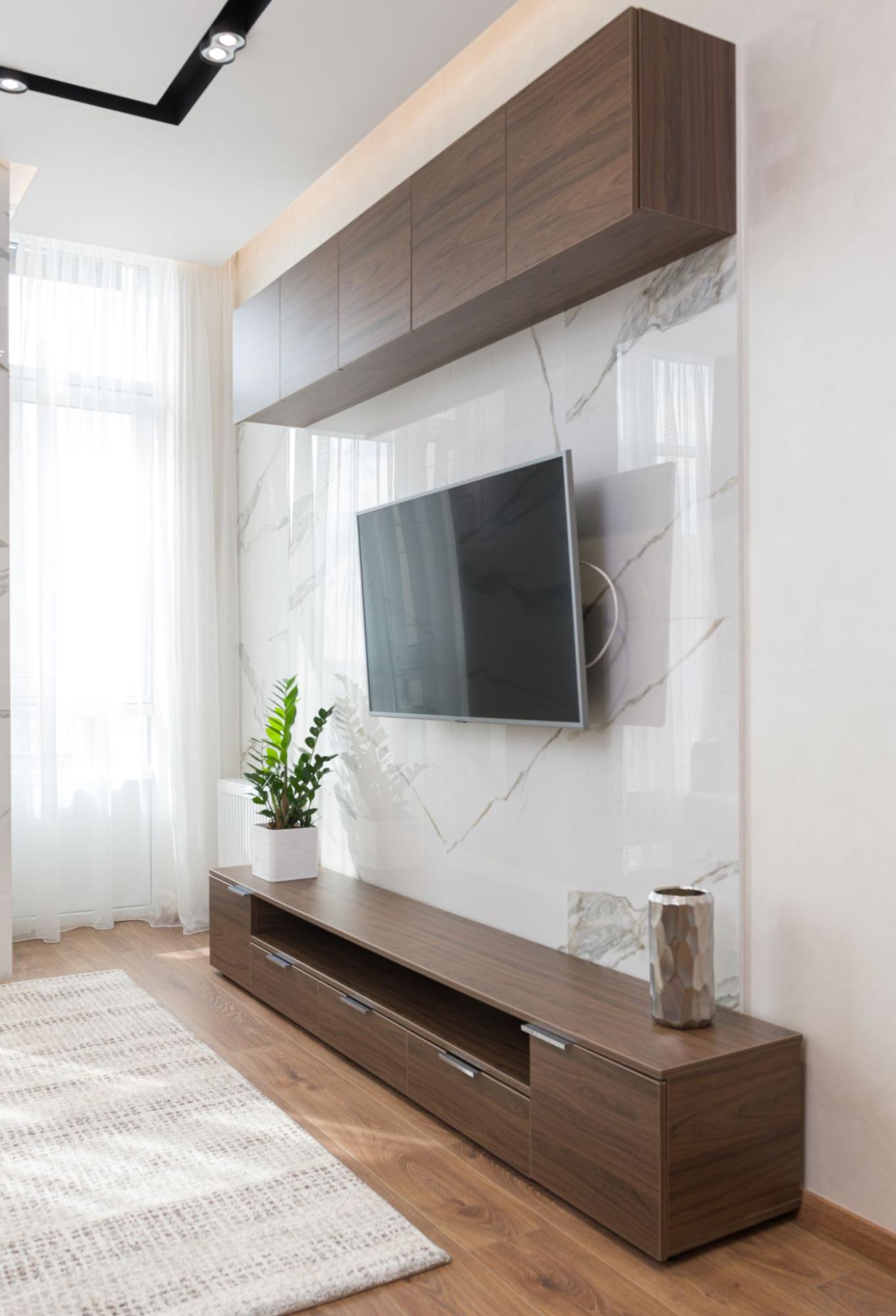 TV mounted on the wall above a dark cabinet