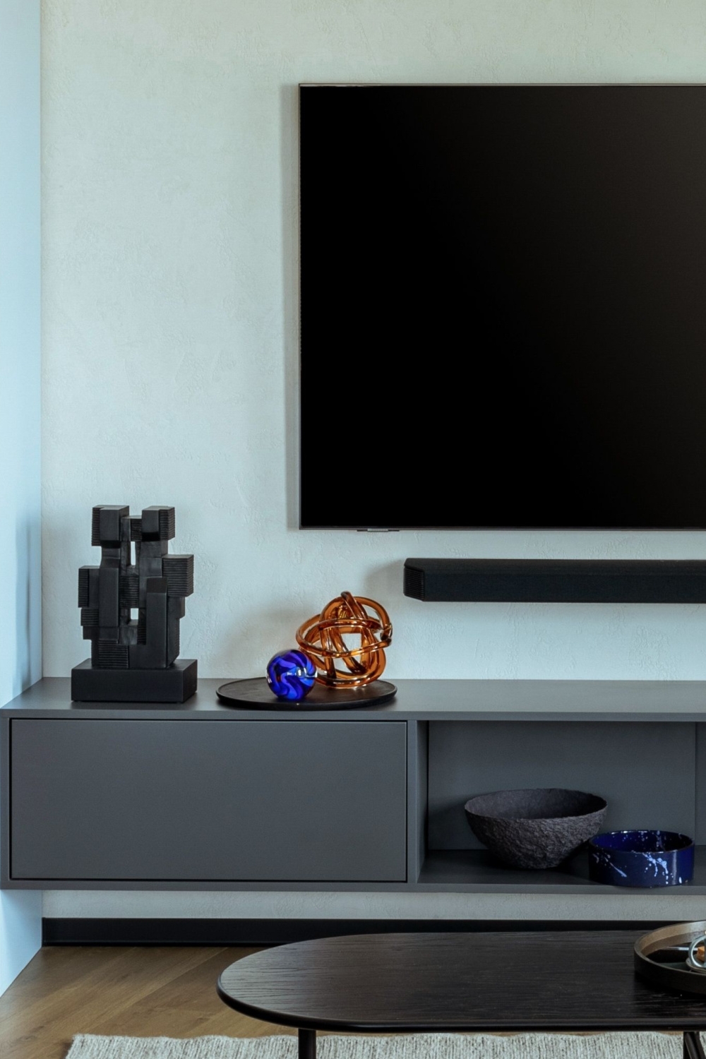 mounted tv and decorations on top a cabinet