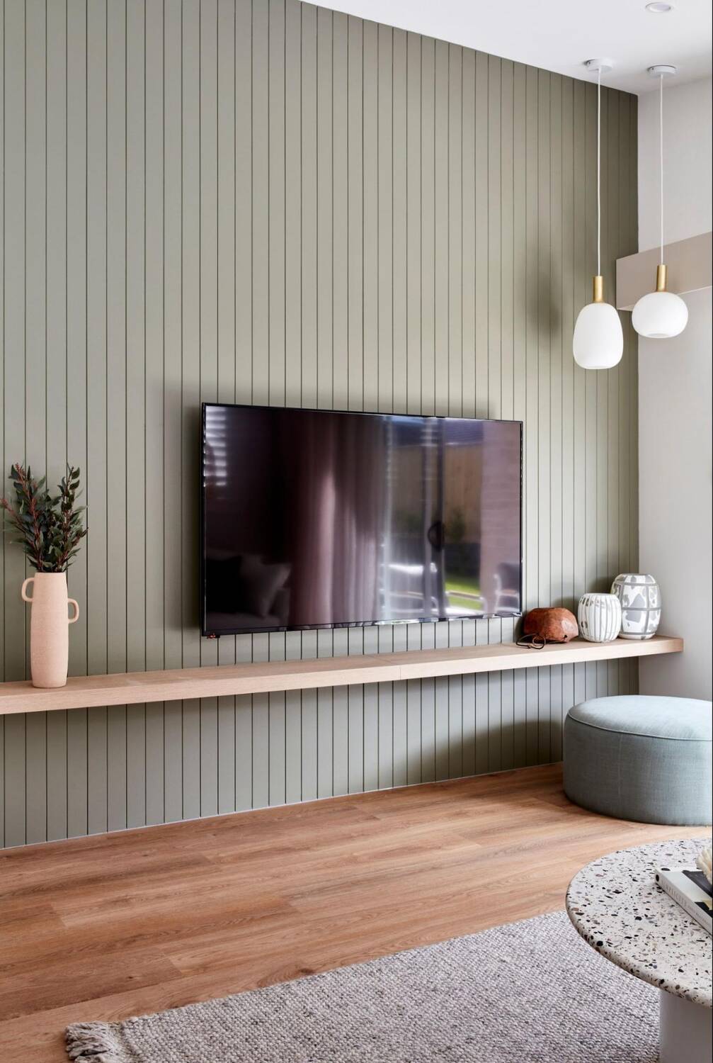 TV mounted on the wall above a shelf
