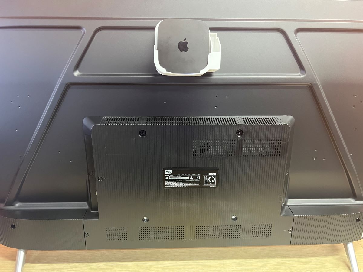 The Apple TV is hide at the back of the TV using a mount to stabilize the device with the TCL TV