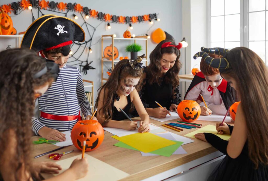 a group of children are coloring their halloween artworks