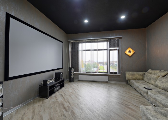 A simple small theater room with big screen and couch