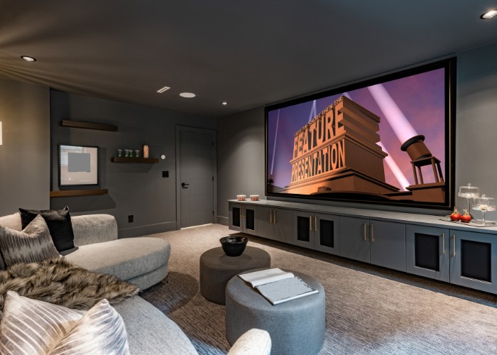 A small theater room with couch and big screen